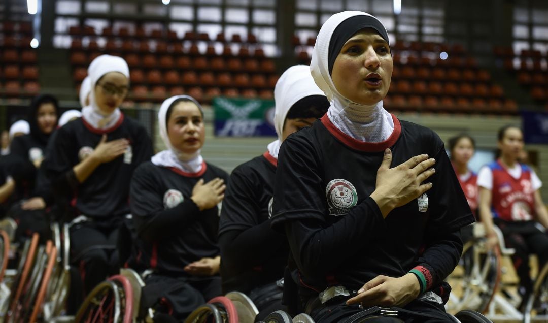 La selección afgana de baloncesto en silla de ruedas escucha el himno, durante un partido en 2018