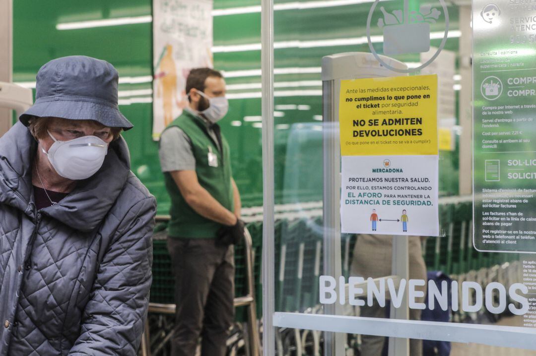 Una mujer con mascarilla a las puertas de un Mercadona.