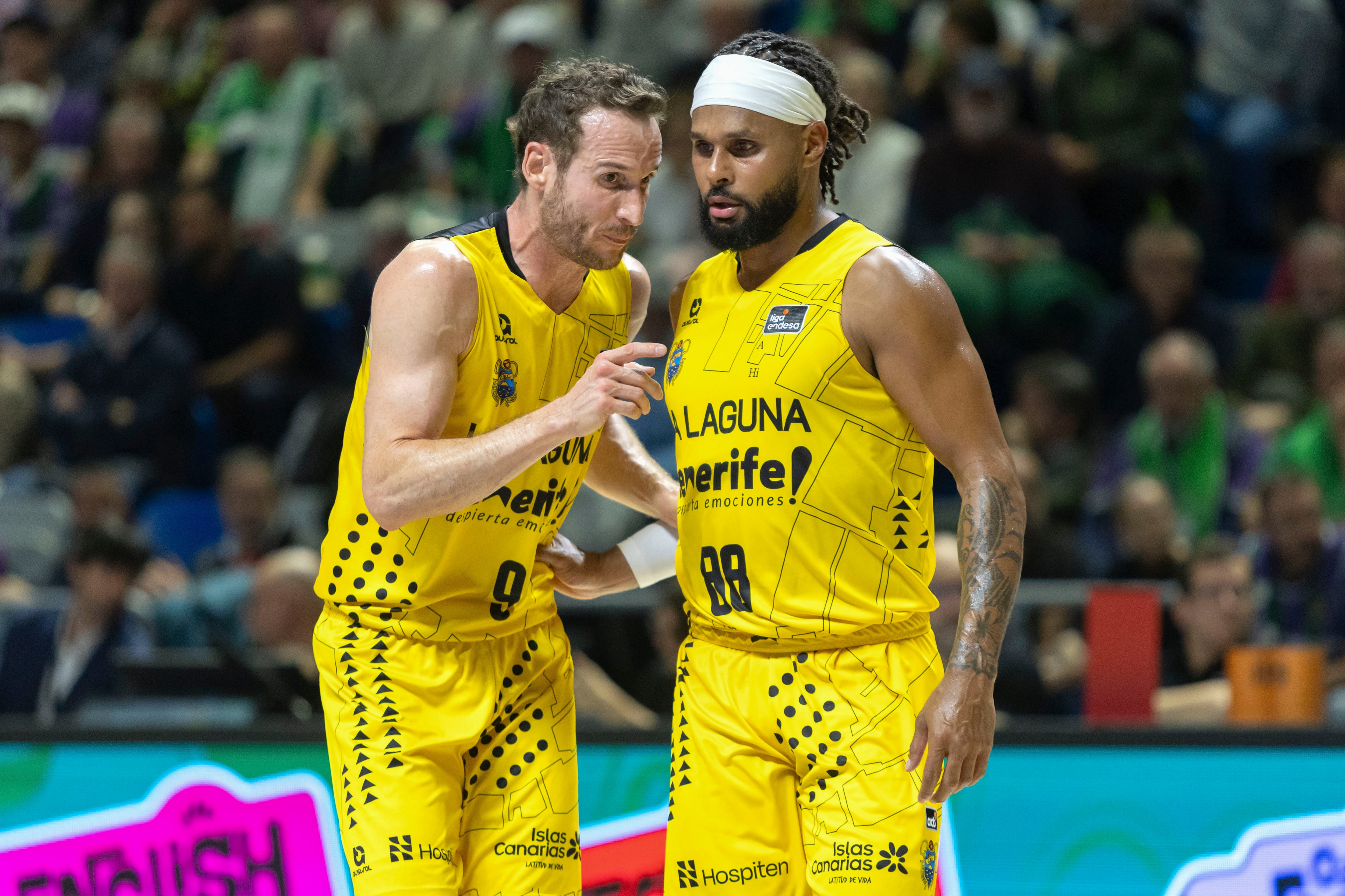 MÁLAGA, 21/03/2026.- El base de La Laguna Marcelinho Huertas (i) conversa con Patty Mills, durante el partido de la Liga Endesa de baloncesto que Unicaja y La Laguna Tenerife disputan este sábado en el Palacio de los Deportes José María Martín Carpena. EFE/ Álvaro Cabrera
