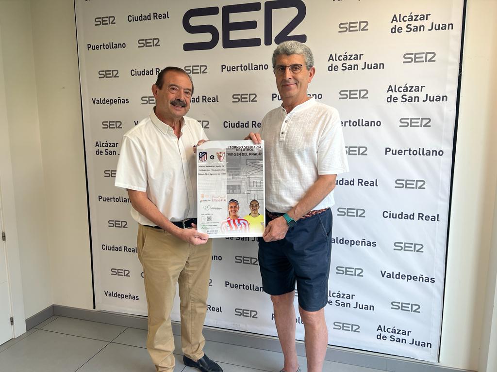 Ángel Pérez, presidente de la junta local de la Asociación contra el Cáncer en Ciudad Real y Enrique Barba, vocal de la Asociación contra el Cáncer en Ciudad Real, presentando el cartel del partido benéfico entre Atlético de Madrid y Sevilla C.F.