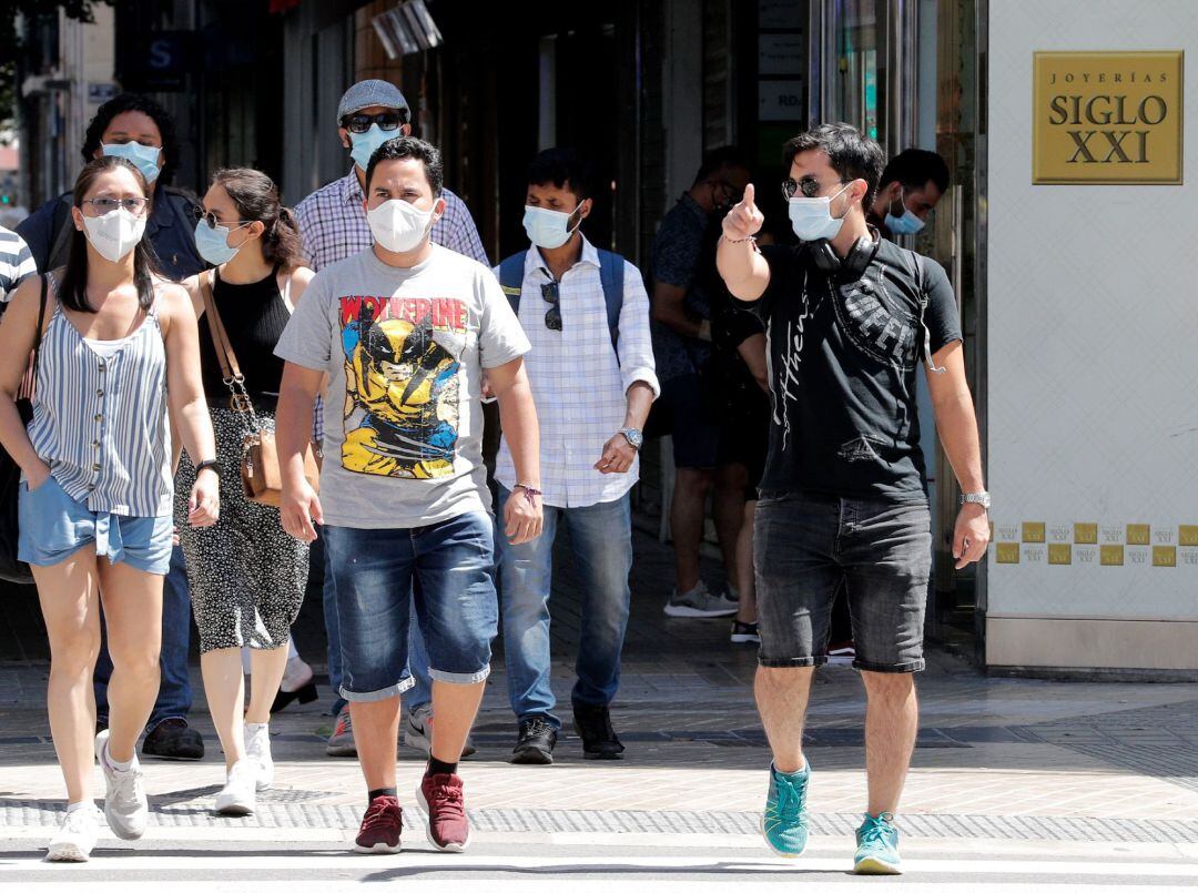 Transeúntes protegidos con mascarillas este sábado por una céntrica calle de Valencia, el día en el que El Consell ha extendido el uso obligatorio de la mascarilla en el espacio público.