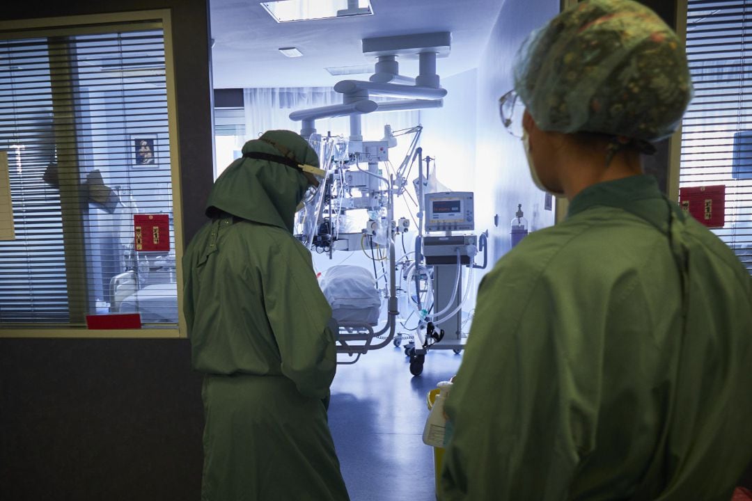 Una trabajadora sanitaria se dispone a entrar para atender a un paciente de una habitación de la UCI de la Clínica Universidad de Navarra