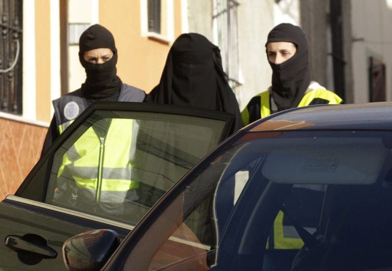 Una de las mujeres detenidas en Melilla a la salida de la vivienda donde ha sido apresada