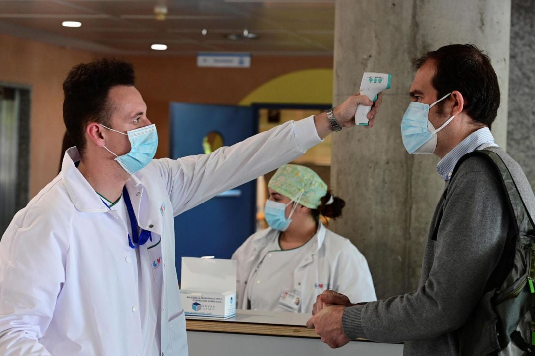 Un sanitario toma la temperatura a un hombre que accede al Hospital de Alcorcón en Madrid, este lunes. 