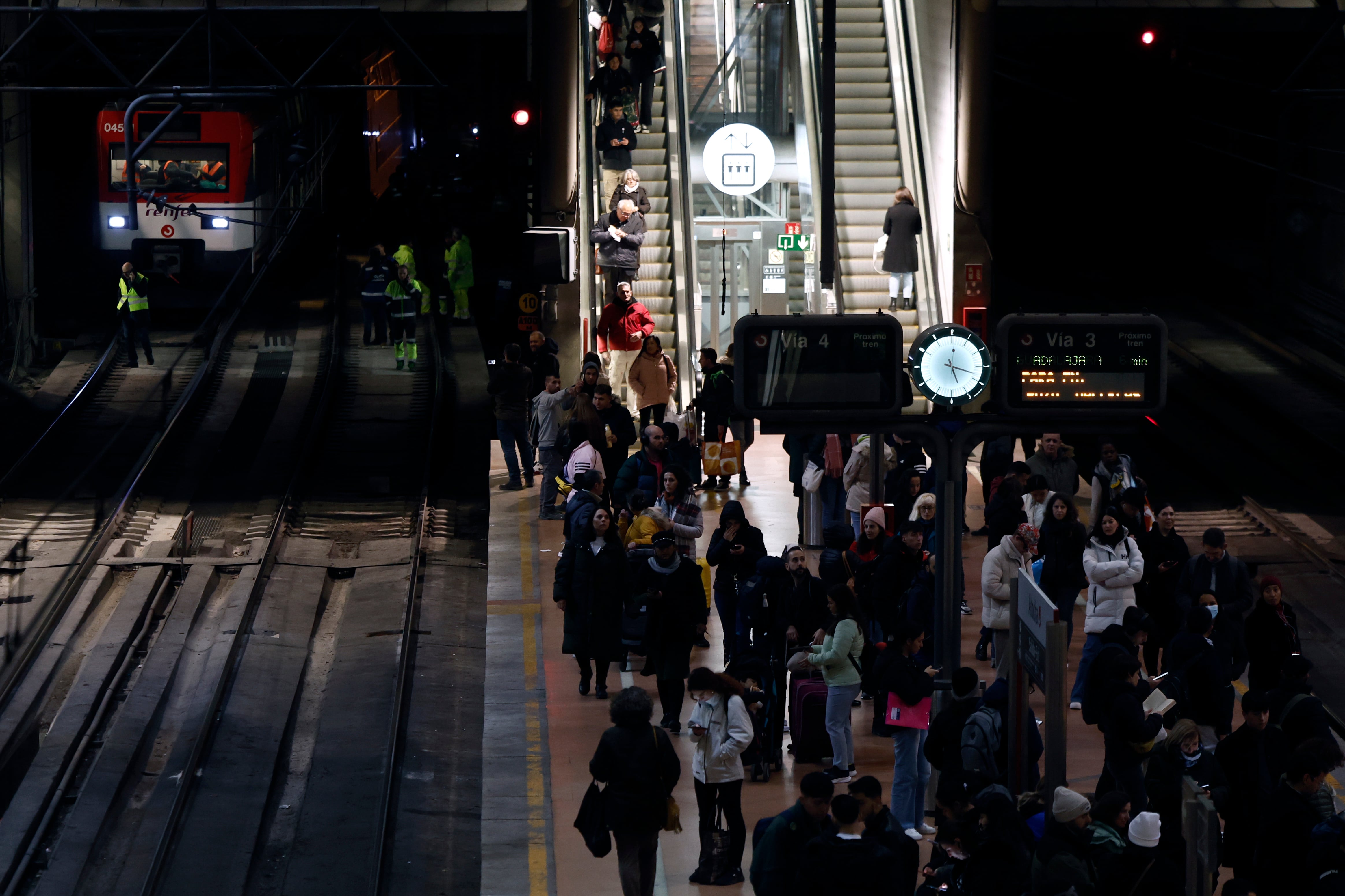 Varias personas esperan en el andén de la estación de Atocha de Madrid, la llegada el tren