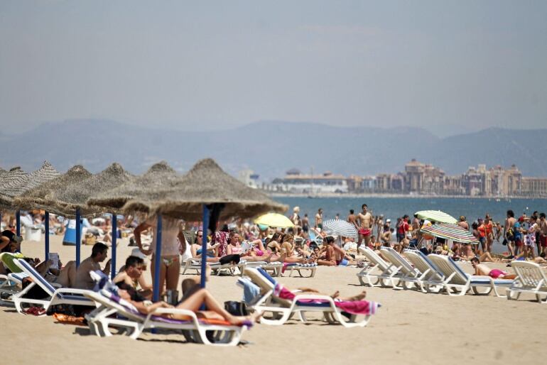 GRA156. VALENCIA, 25/06/2015.- Numerosos valencianos y turistas disfrutan del sol, ya hoy viernes, en las playas de La Malvarrosa y Las Arenas de Valencia. Hoy comienza un fin de semana de tiempo estable y altas temperaturas en toda España, que pueden superar los 26 grandos en la Comunidad Valenciana. EFE/Manuel Bruque