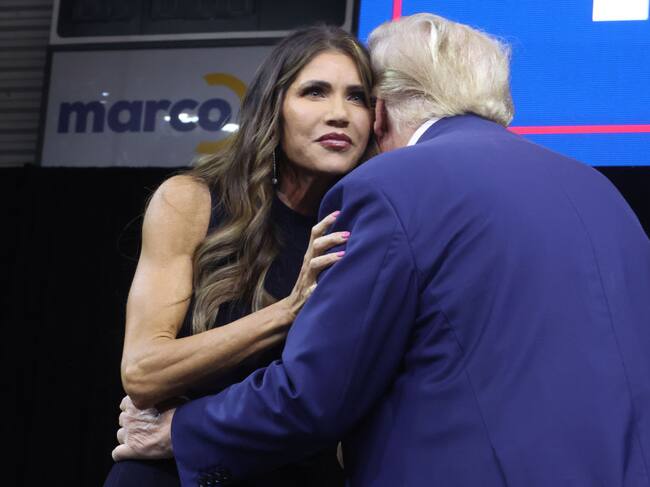 Donald Trump saluda a Kristi Noem durante un mitin.