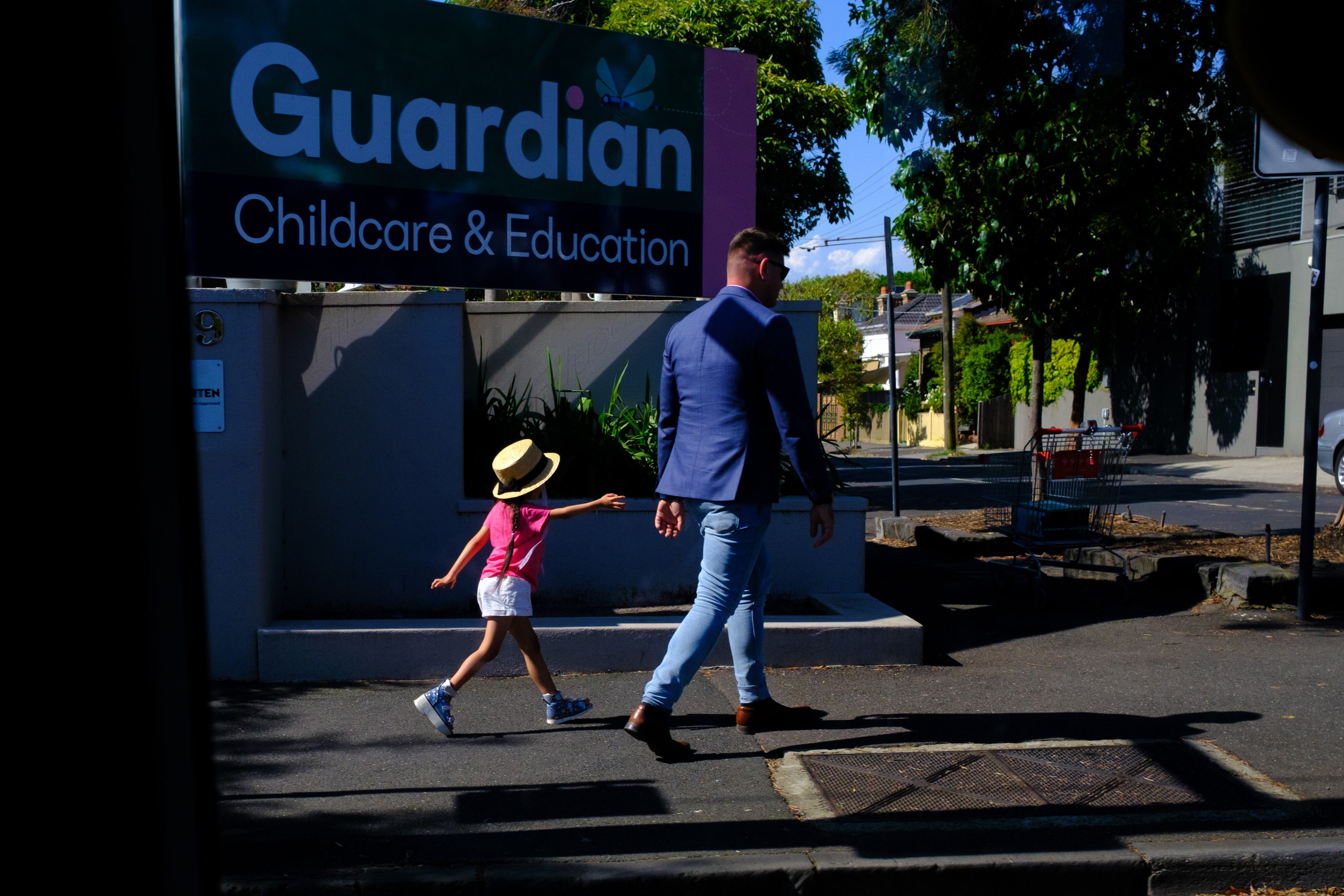 Un hombre y una niña pasan frente a una guardería el 23 de enero de 2023 en Melbourne, Australia. Alexi Rosenfeld/Getty Images.