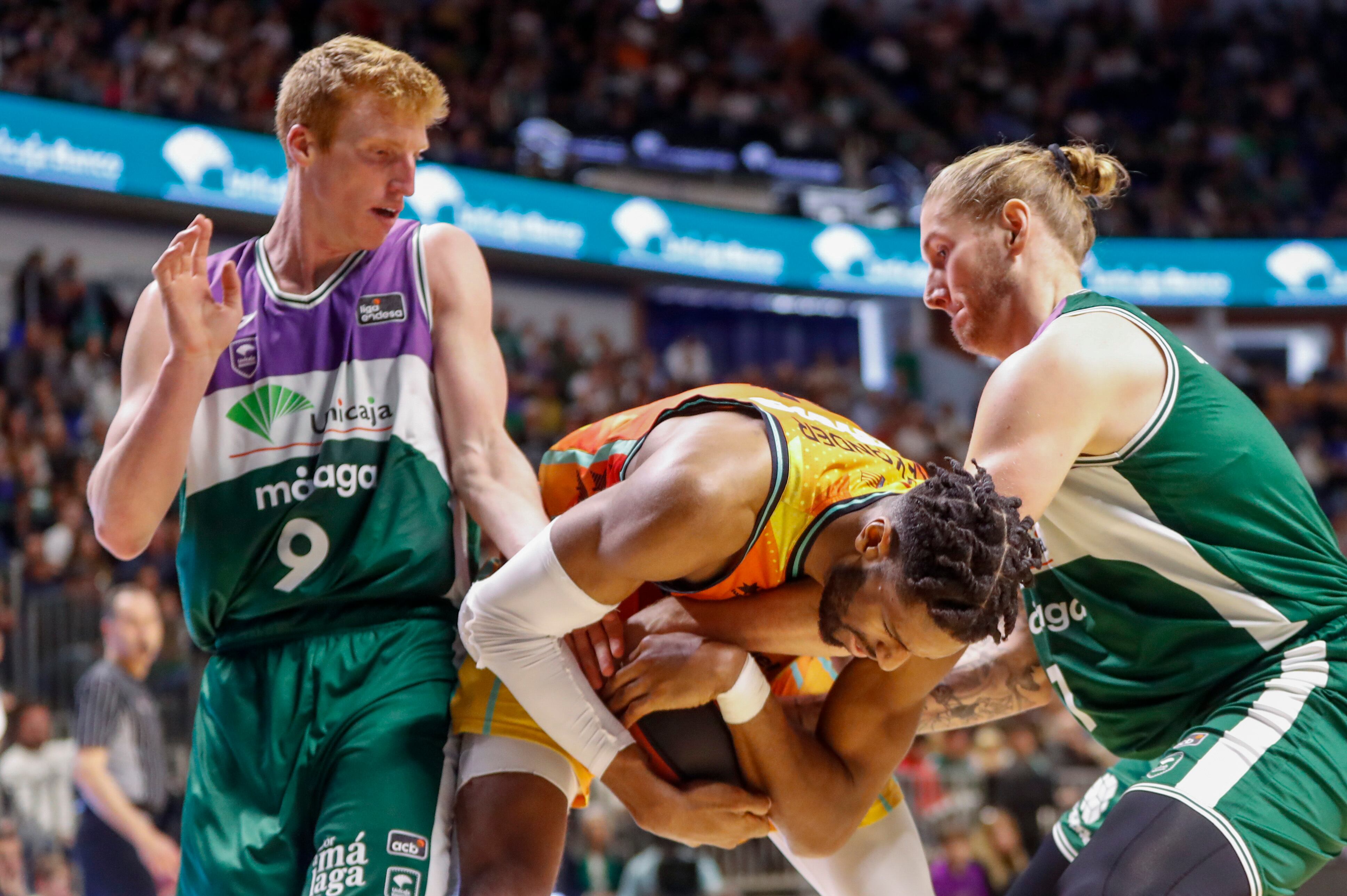 MÁLAGA, 29/01/2023.- El jugador canadiense del Valencia Basket, Kyler Alexander (c) lucha por el balón con el base Alberto Díaz (i) del Unicaja durante su partido correspondiente a la Liga ACB disputado en el pabellón Martín Carpena de Málaga este domingo. EFE/ Jorge Zapata