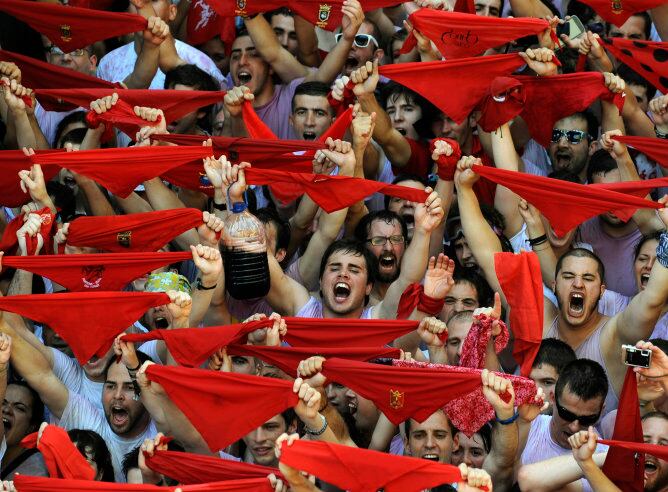 Los asistentes levantan sus pañuelos rojos para celebrar el inicio de las fiestas en honor a San Fermín