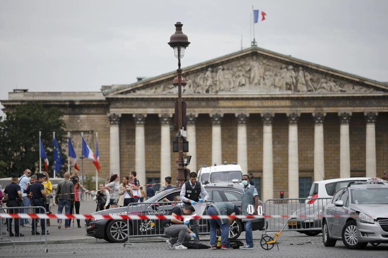 French police look for clues after a car drove through barriers set up for the final stage of the Tour de France in central Paris, France, July 26, 2015. Police opened fire on a car which drove through barriers after refusing to obey them near the Place d