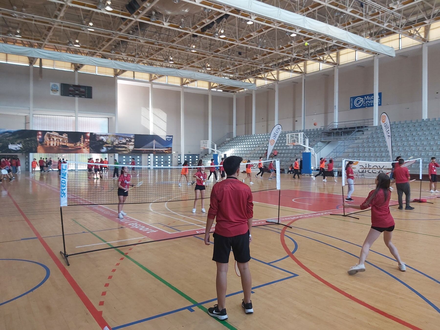 Vista general del pabellón Mutua Levante con partidos de badminton y baloncesto