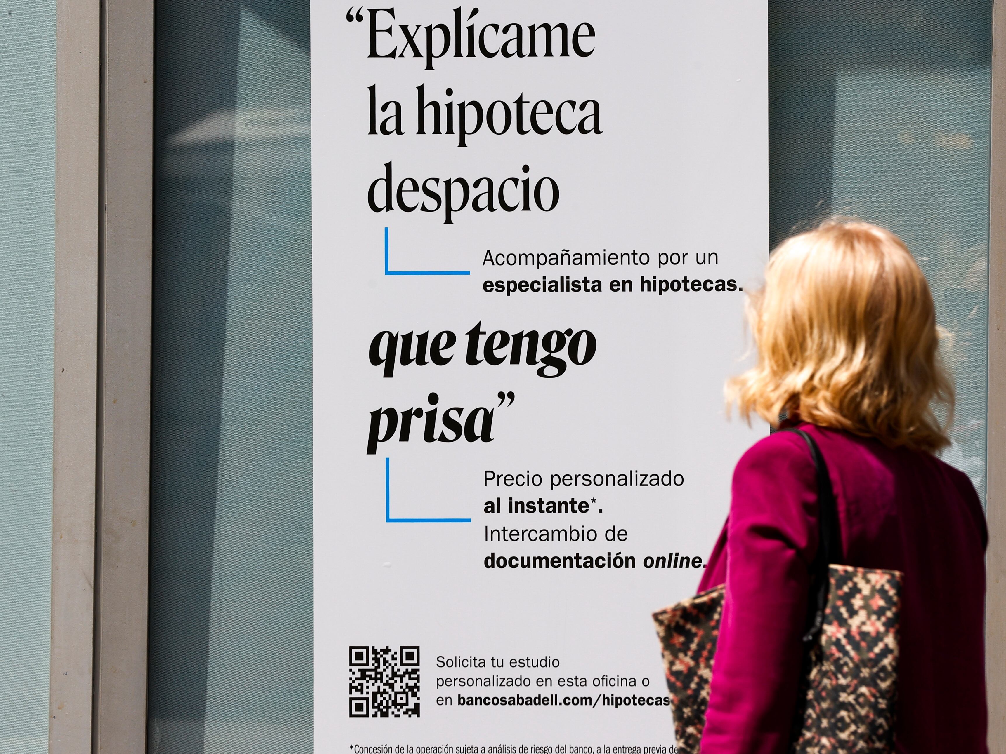 Una mujer ante un cartel bancario sobre las hipotecas. EFE/Luis Tejido