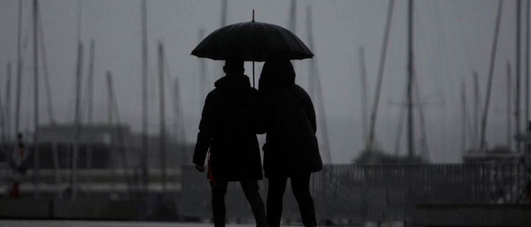 Dos personas caminan bajo la lluvia en la ciudad de A Coruña