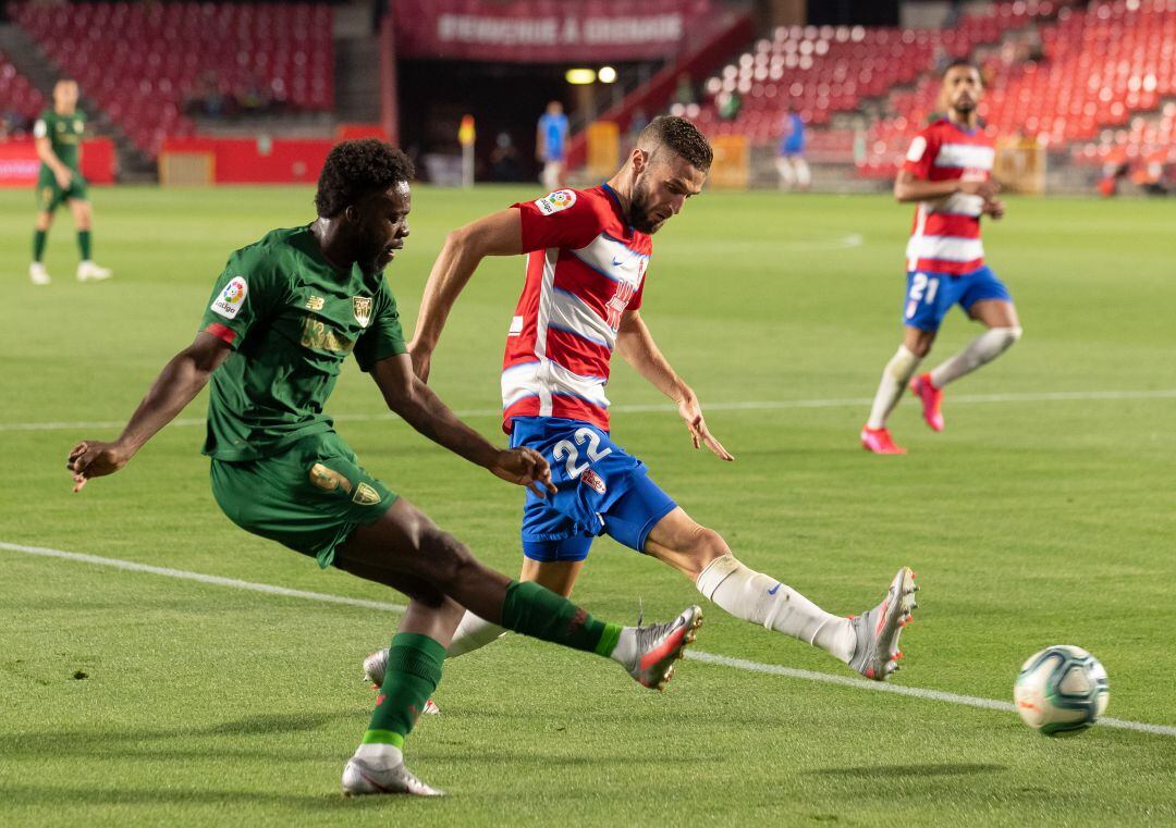 Iñaki Williams y Domingos de Sousa disputan un balón durante el Granada - Athletic.