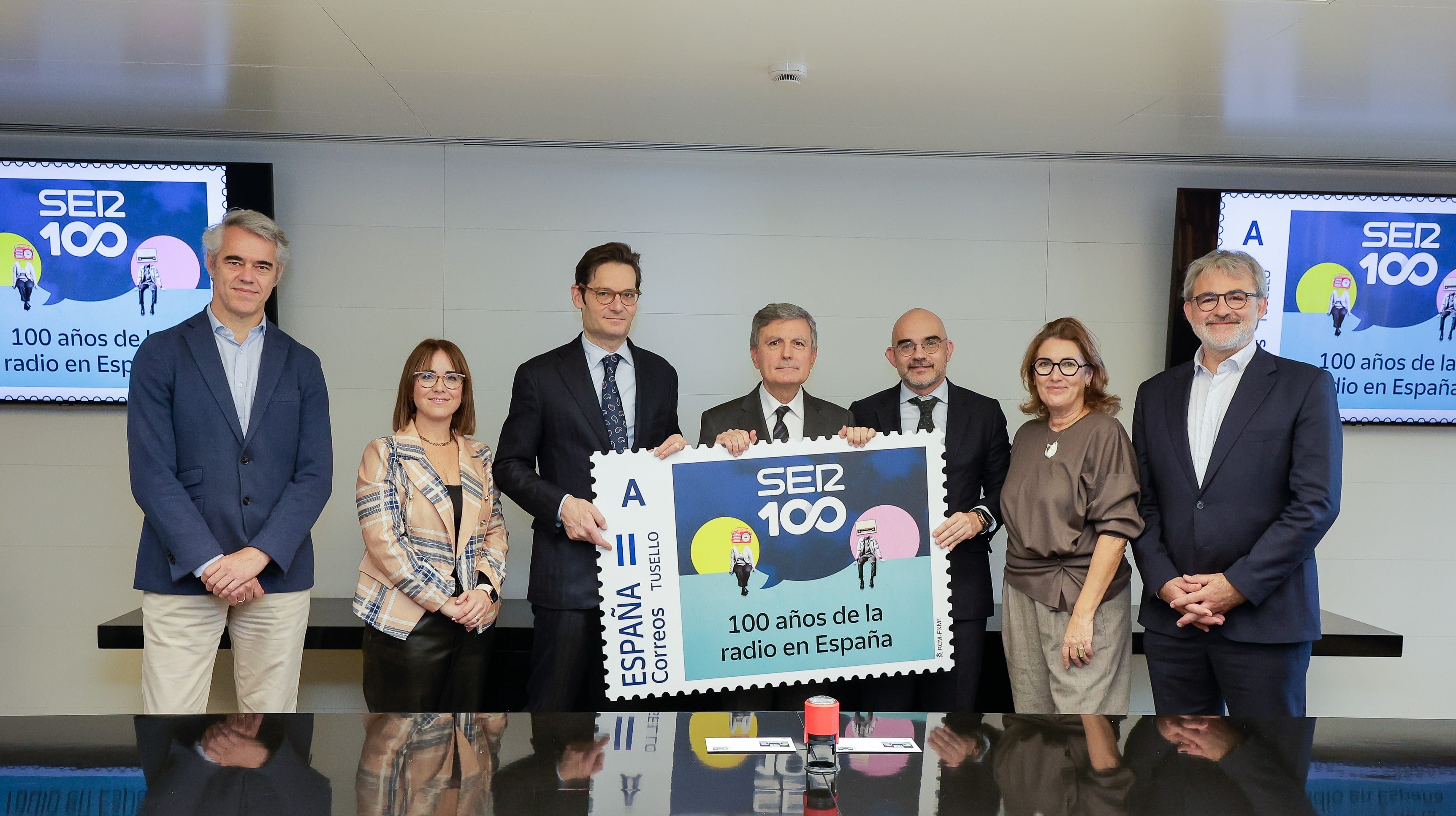 Ignacio Soto, director general de la SER;  Nuria Lera Hervás, directora de Filatelia i Relacions Institucionals de Correus; Joseph Oughourlian, president de PRISA; Pedro Saura, president de Correus; Carlos Nuñez, president executiu de PRISA Media; Montserrat Domínguez, directora de Continguts de la SER i Jaume Serra, director del Centenari