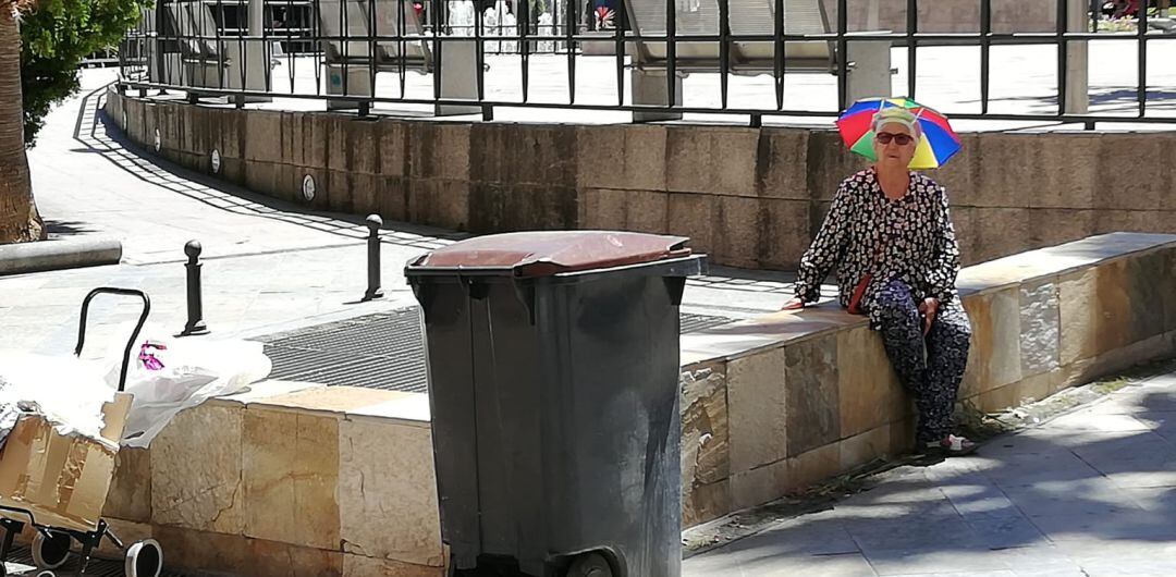 Una mujer con una sombrilla en la cabeza soporta el calor de estos días en la capital.