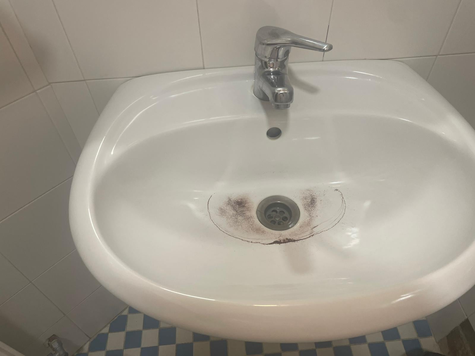 Imagen de un lavabo de la residencia tras abrir el agua del grifo.