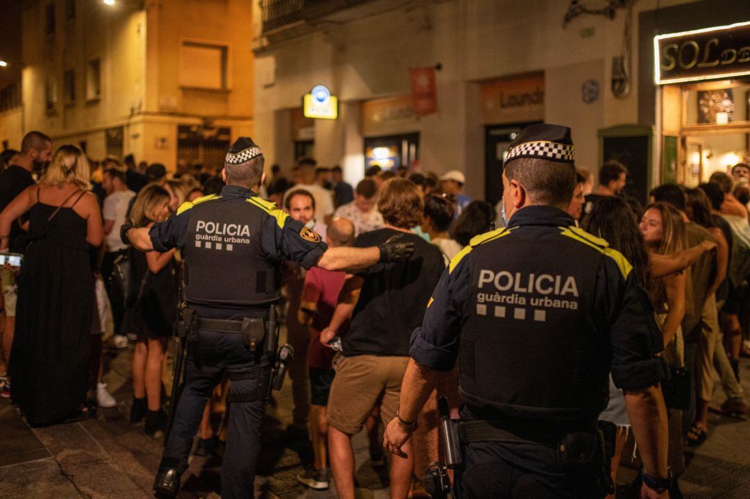 Agents de la Guàrdia Urbana desallotjant a les persones congregades aquesta matinada al barri de Gràcia