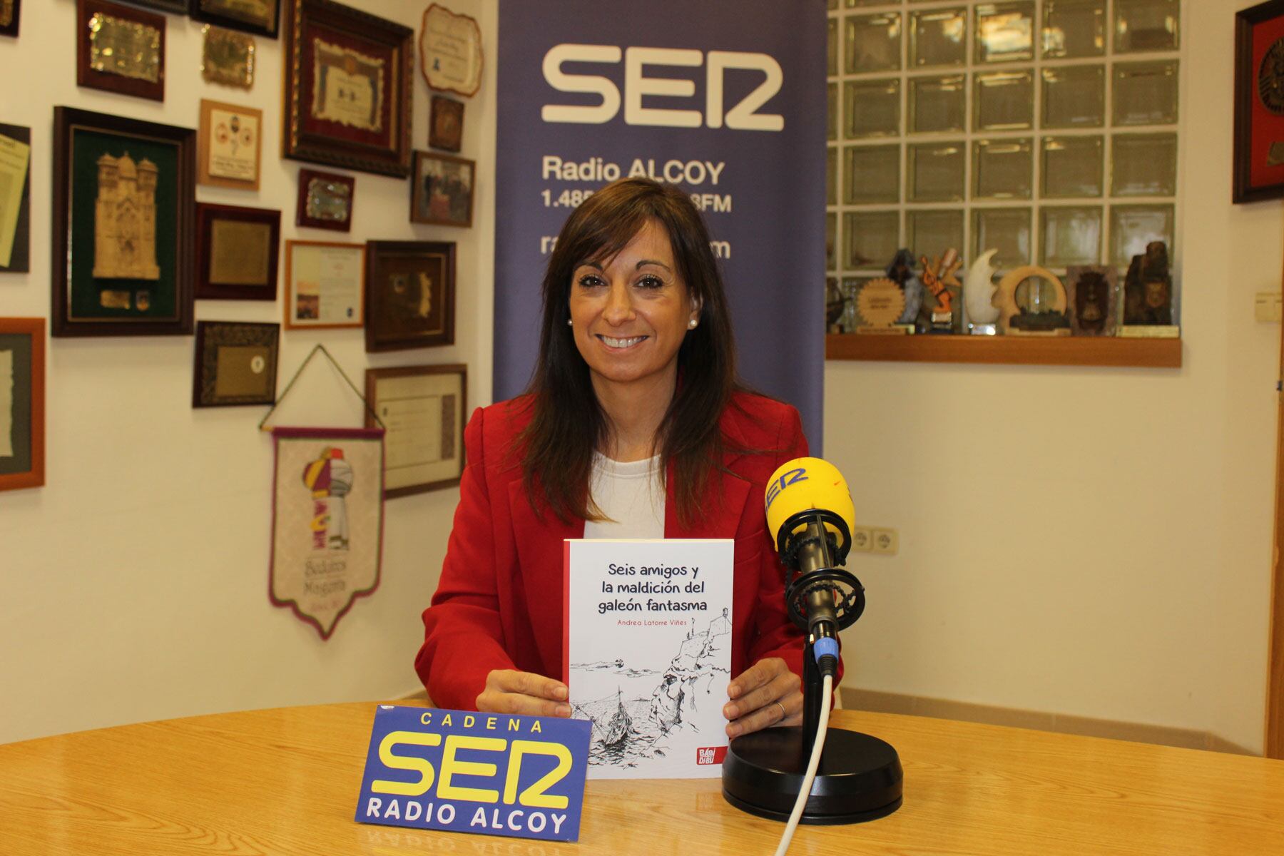 Andrea Latorre, en el estudio central de Radio Alcoy, con un ejemplar de su tercer libro