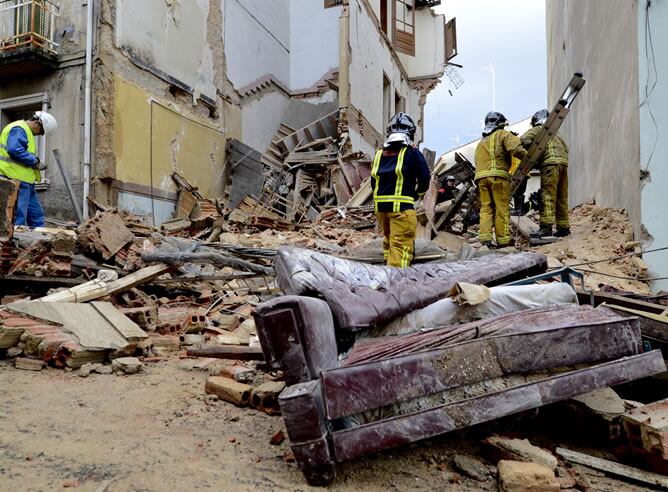 Los bomberos trabajan para excarcelar a una persona de avanzada edad que se encuentra bajo los escombros del edificio que se ha desplomado esta mañana en la calle Villa Valencia nº 6 de Ourense.