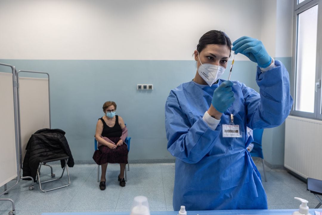 Una enfermera prepara una vacuna para una mujer italiana en un hospital de Milan.