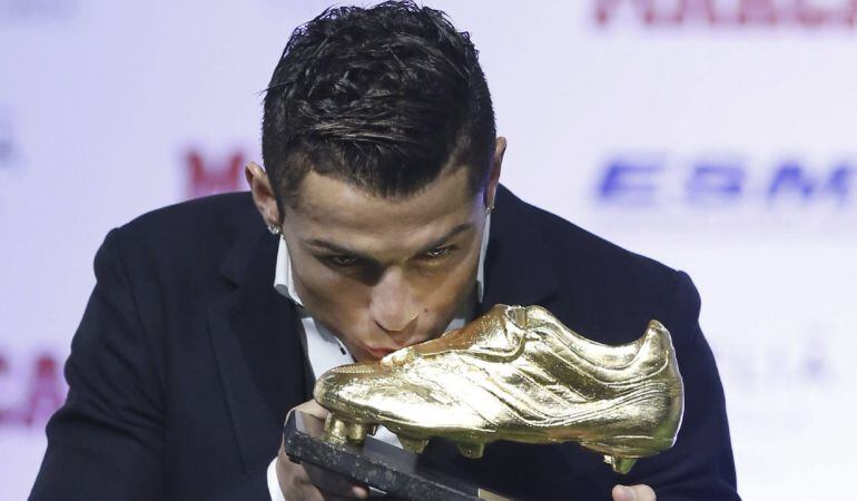 Cristiano Ronaldo besa la Bota de Oro 2013-2014 tras recibir el trofeo de manos del presidente del club, Florentino Pérez