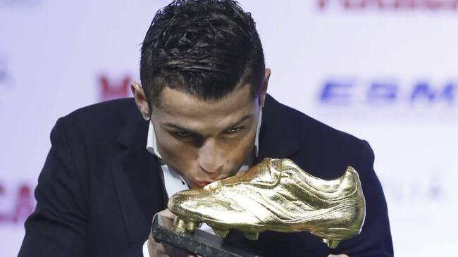 Cristiano Ronaldo besa la Bota de Oro 2013-2014 tras recibir el trofeo de manos del presidente del club, Florentino Pérez