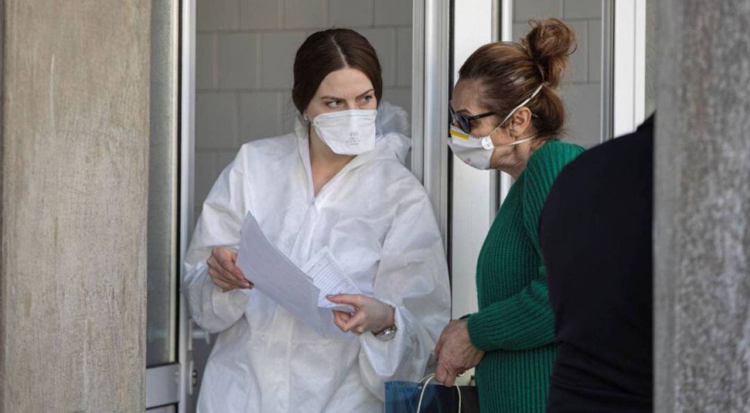 Una profesional sanitaria habla con una mujer.