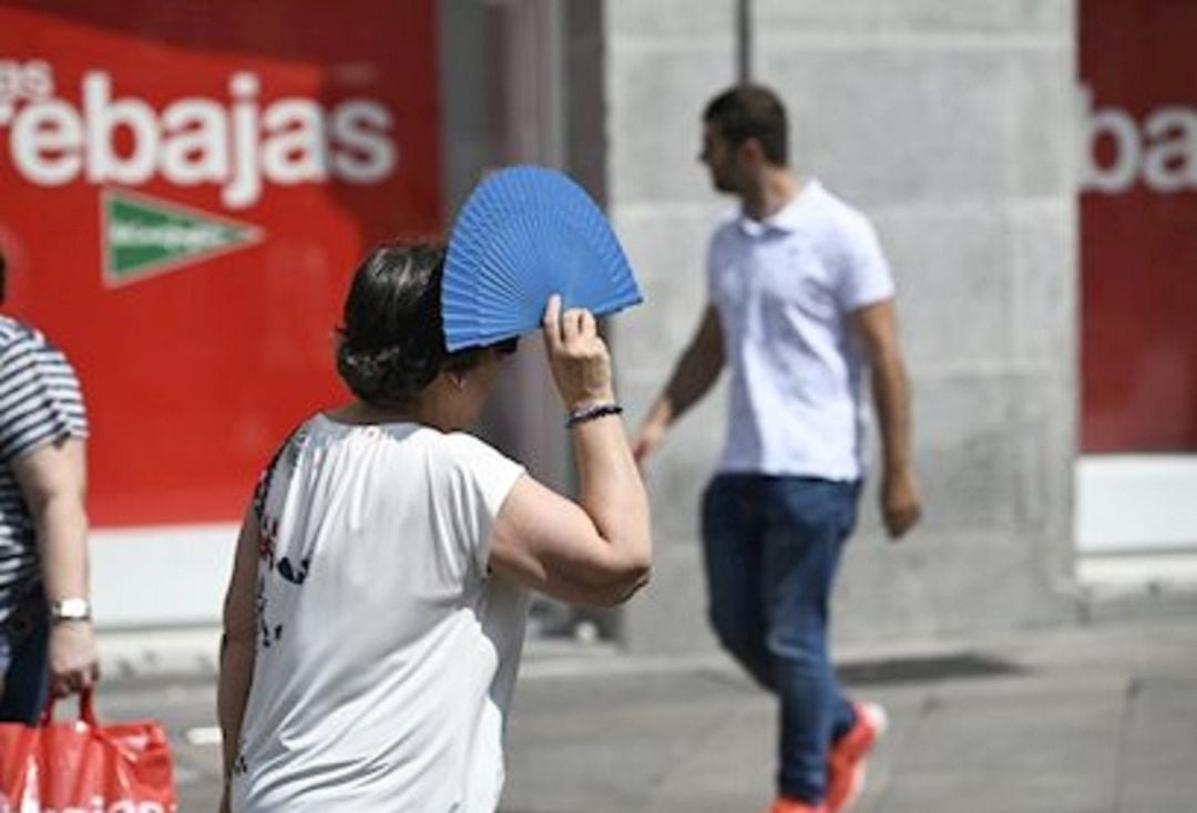 Gente por la calle huyendo del sol