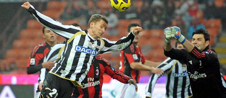 El centrocampista del Udinese Calcio Almen Abdi remata de cabeza ante el portero del AC Milan Marco Amelia