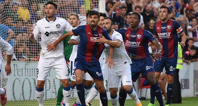 Los jugadores del Huescan intentan rematar un córner en área rival