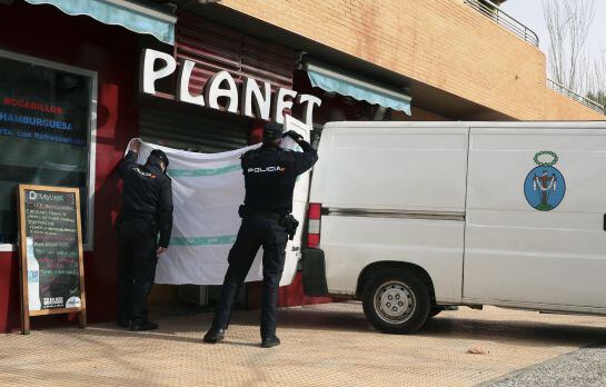 Agentes de la Policía Nacional, a las puertas del bar Planet, proceden al levantamiento de los cadáveres de un hombre y una mujer.