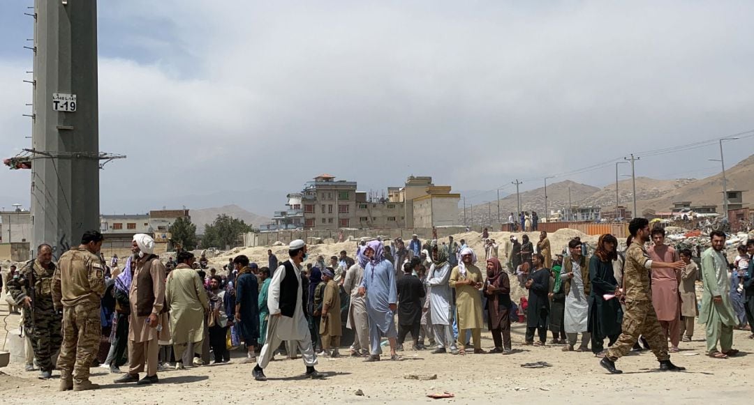 Kabul (Afghanistan), 17-08-2021.- Afghan security officials stand guard as people gather outside the Hamid Karzai International Airport to flee the country, after Taliban took control of Kabul, Afghanistan, 17 August 2021. Several people were reportedly k