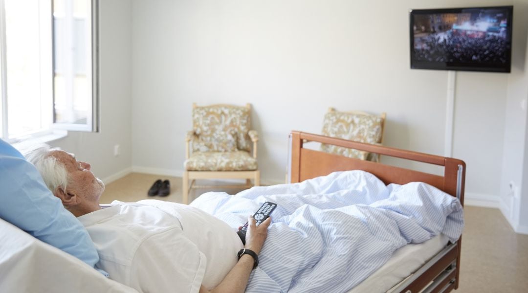 Un paciente ve la televisión desde la cama del hospital.