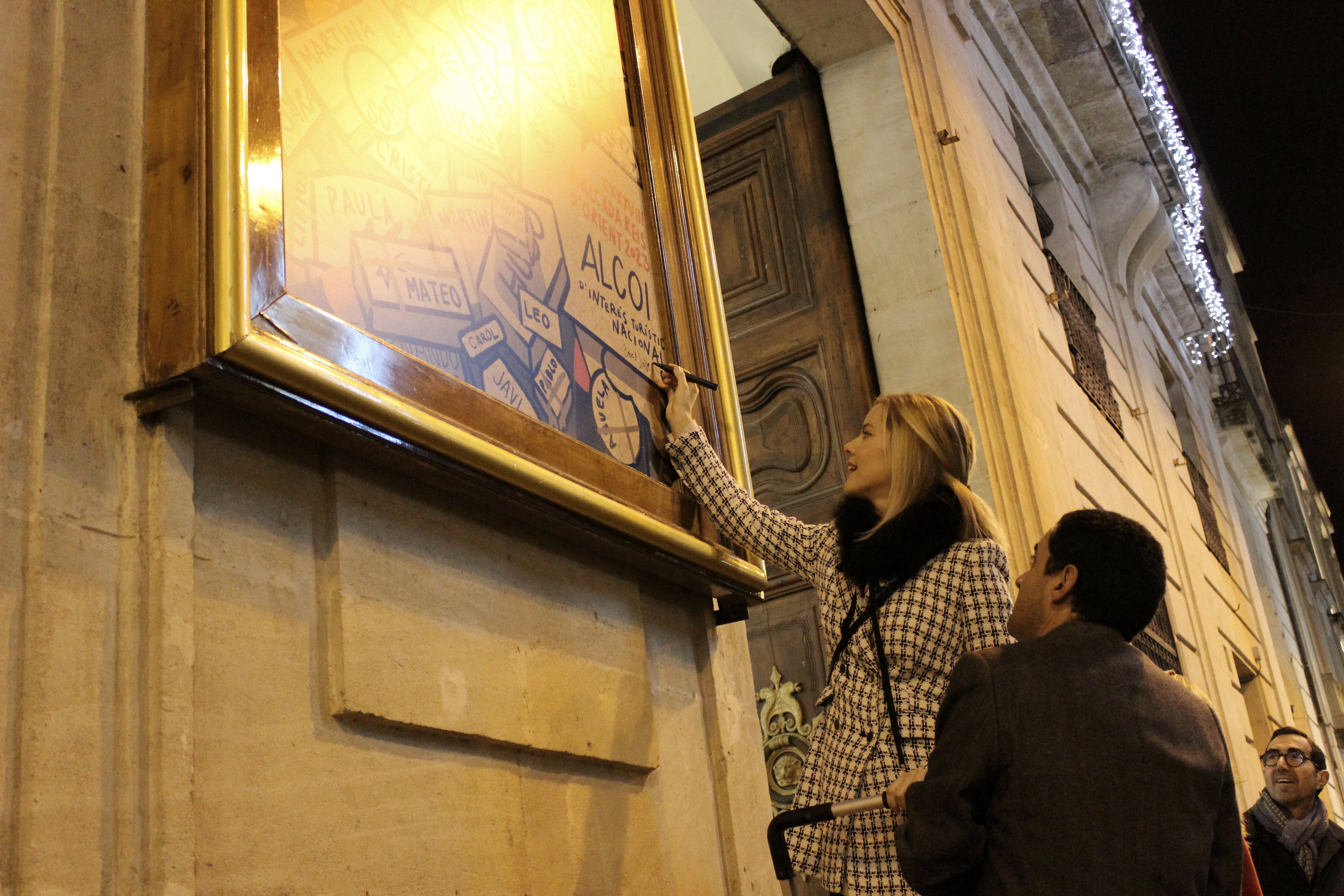 Beca Jover firmando en el cartel que ha creado para anunciar la 138 Cabalgata de Melchor, Gaspar y Baltasar por las calles de Alcoy.