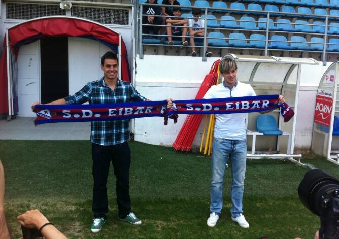 Dani García y Javi Lara posan con la bandera del Eibar sobre el césped de Ipurua.