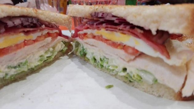 El sándwich de pollo completo, partido en dos mitades