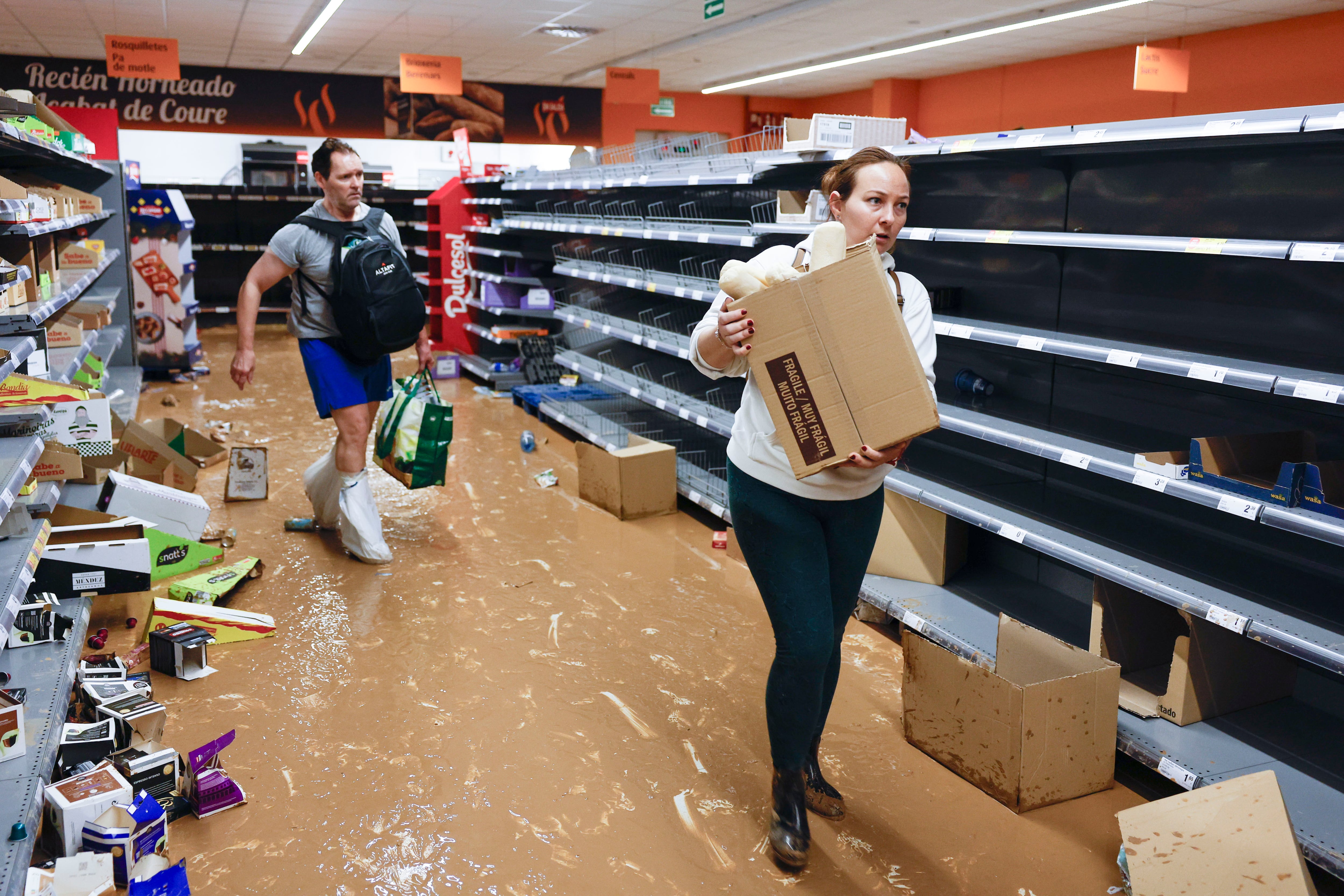 Varios residentes recogen alimentos en un supermercado en la localidad de Paiporta, Valencia, este jueves. L