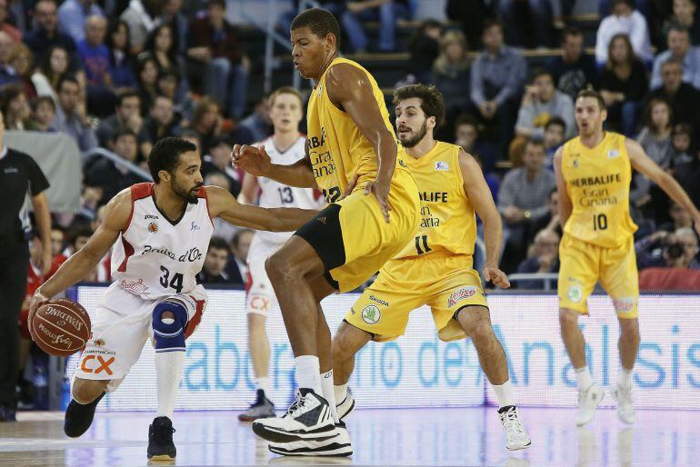 GRA099. MANRESA (BARCELONA), 16/11/2014.- El base estadouniense de La Bruixa d'Or Manresa, Davin White (i), ataca con el balón ante Samuel Tavares (22) y Tomás Bellas (11), del Herbalife Gran Canaria, durante el partido de la séptima jornada de la liga ACB de baloncesto que se duisputa en el Nou congost de Manresa. EFE/Susanna Sáez