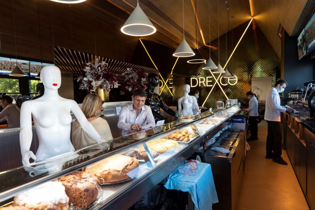 Varias personas toman café en la barra de una cafetería de Murcia, en la que han colocado maniquíes para que los clientes guarden la distancia de seguridad para evitar contagios de Covid-19