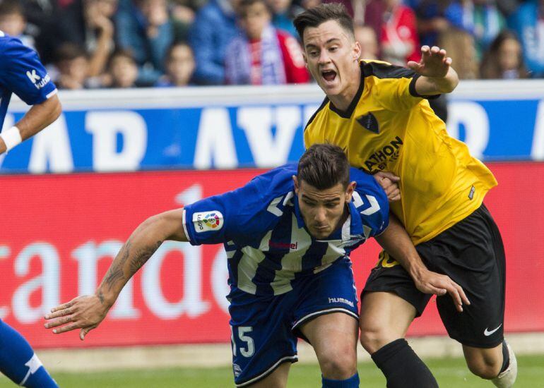 Theo Hernández disputa el balón con el centrocampista venezolano del Málaga &#039;Juanpi&#039; Añor.