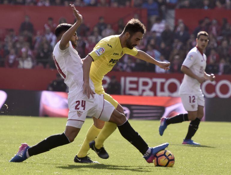 El defensa argentino del Sevilla FC, Gabriel Mercado, disputa un balón con el delantero del Villarreal CF, Adrián López.