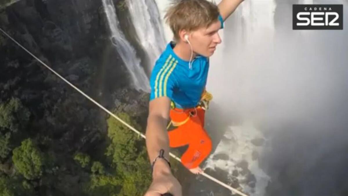 Dos jóvenes cruzan sobre una cinta elástica las Cataratas Victoria