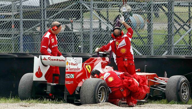 Operarios de Ferrari retiran el Ferrari del español, que ha sufrido un accidente en los test de Mugello