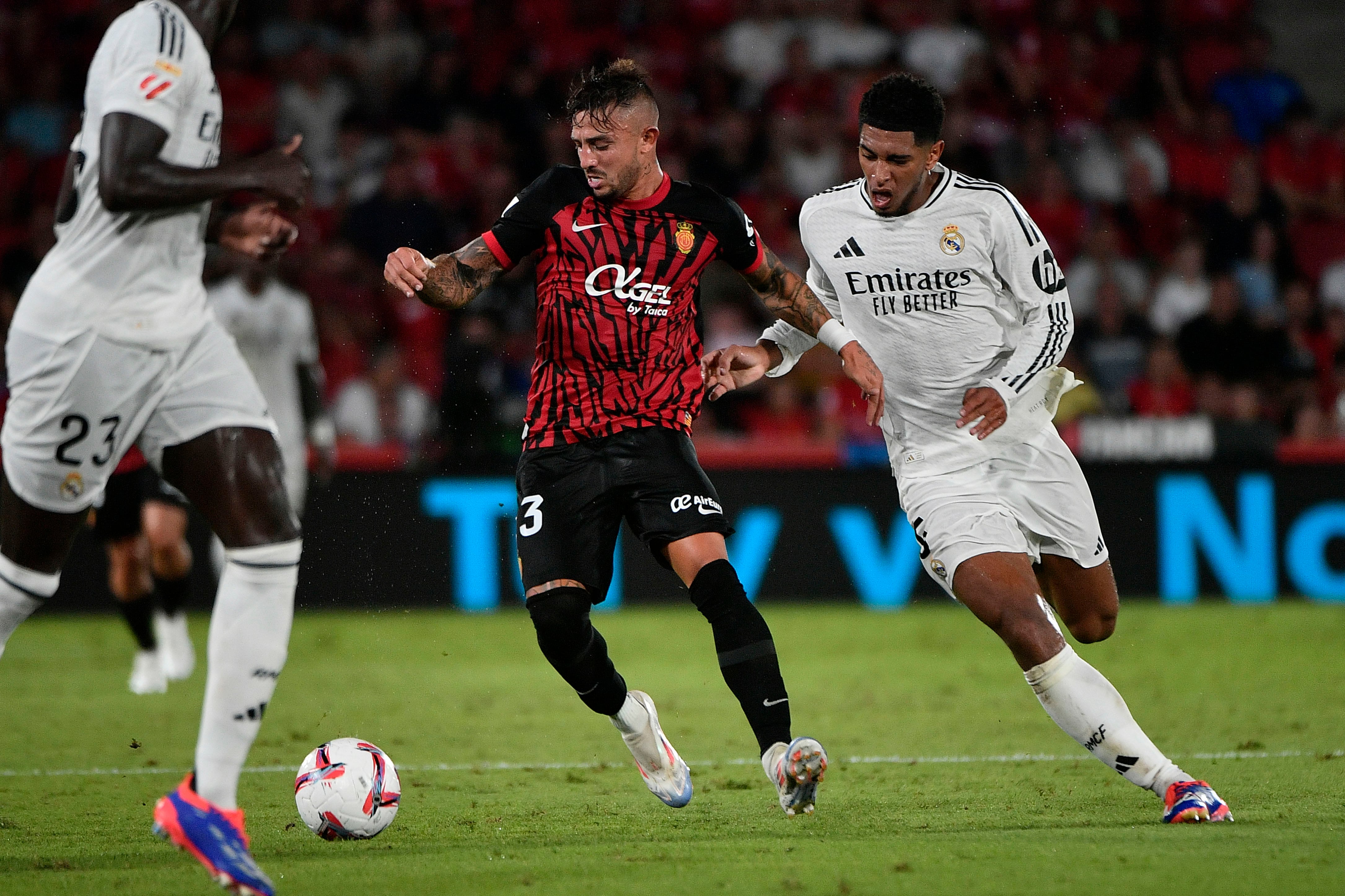 PALMA, 18/08/2024.- El centrocampista del RCD Mallorca Pablo Maffeo (c) disputa una posesión con el centrocampista del Real Madrid Jude Bellingham (d) durante el partido de LaLiga entre el RCD Mallorca y el Real Madrid, este domingo en el estadio de Son Moix, en Palma. EFE/ Miquel A. Borràs
