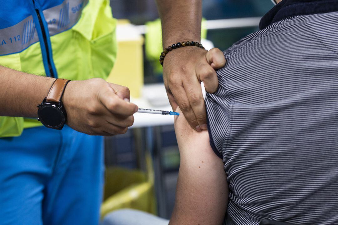 Un sanitario administra una dosis de la vacuna de Pfizer a un hombre en el Wizink Center.