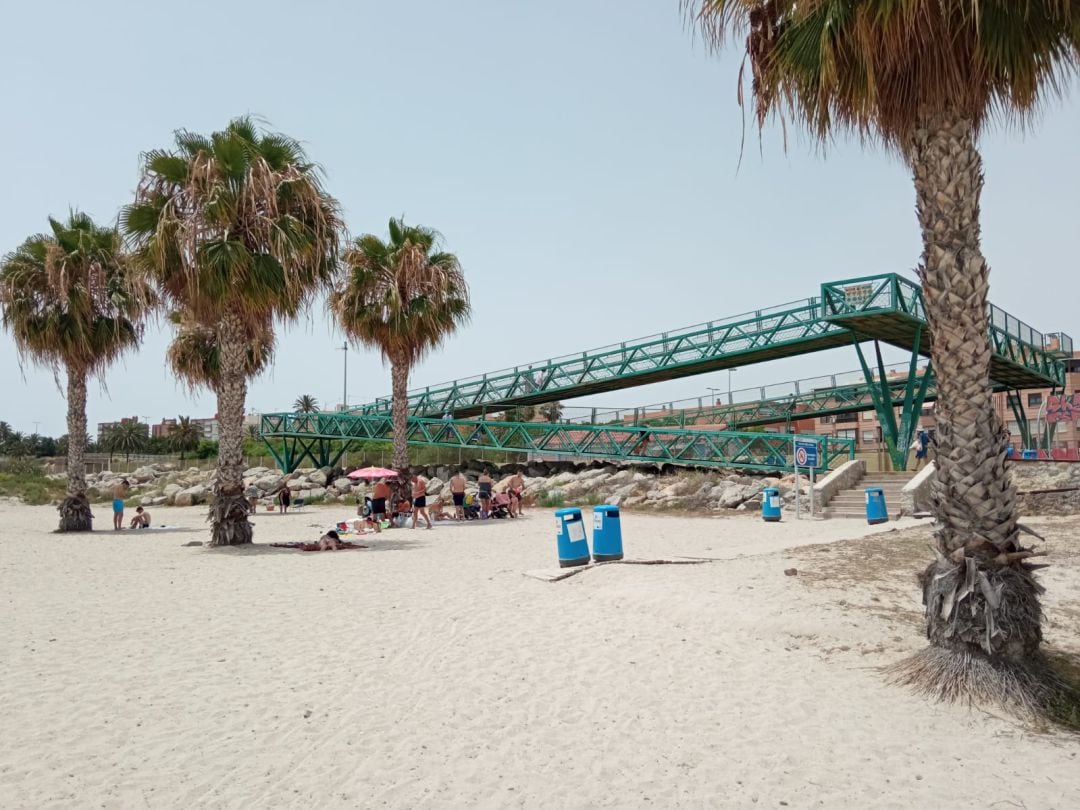 Turistas y residentes toman el sol en la playa de San Gabriel junto al cartel municipal que en su momento prohibió el baño. Imagen de archivo