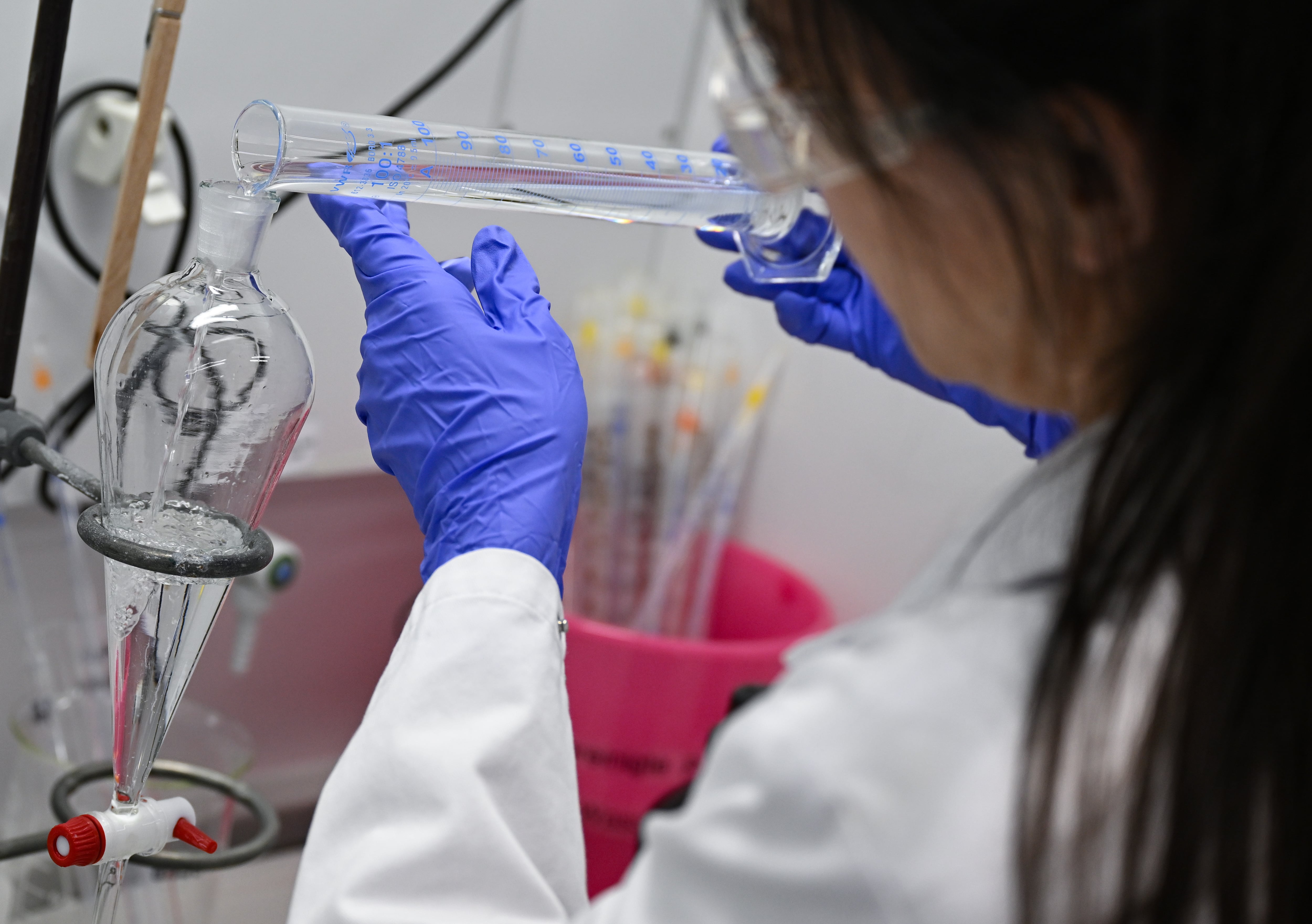 Una mujer trabaja en el desarrollo de un fármaco en un laboratorio de biotecnología.