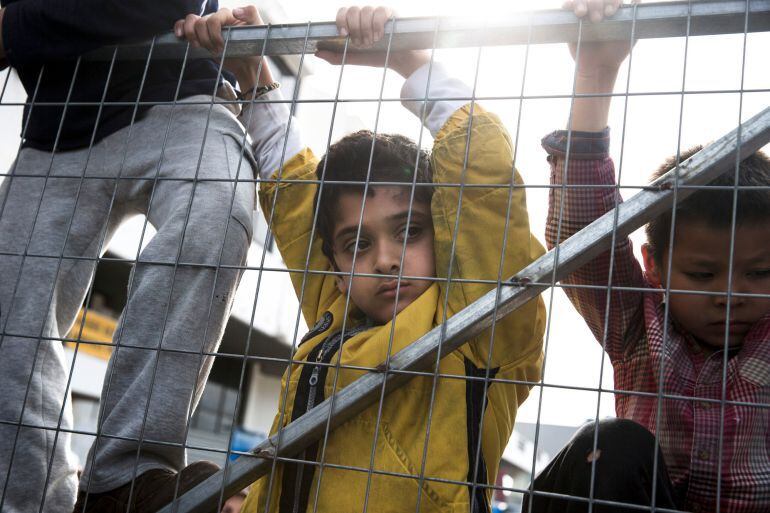 Niños escalan la entrada del campo de refugiados en el aeropuerto de Hellenikon en Grecia.